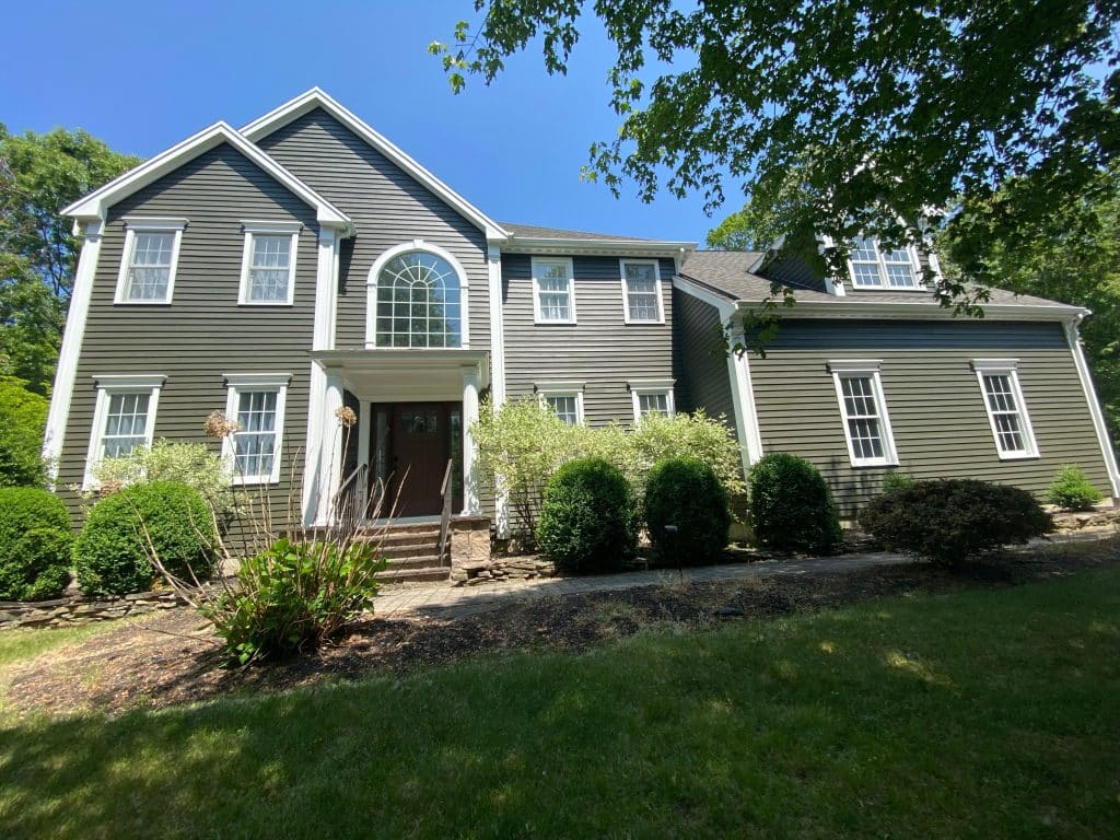 large two story home with dark green painted exterior